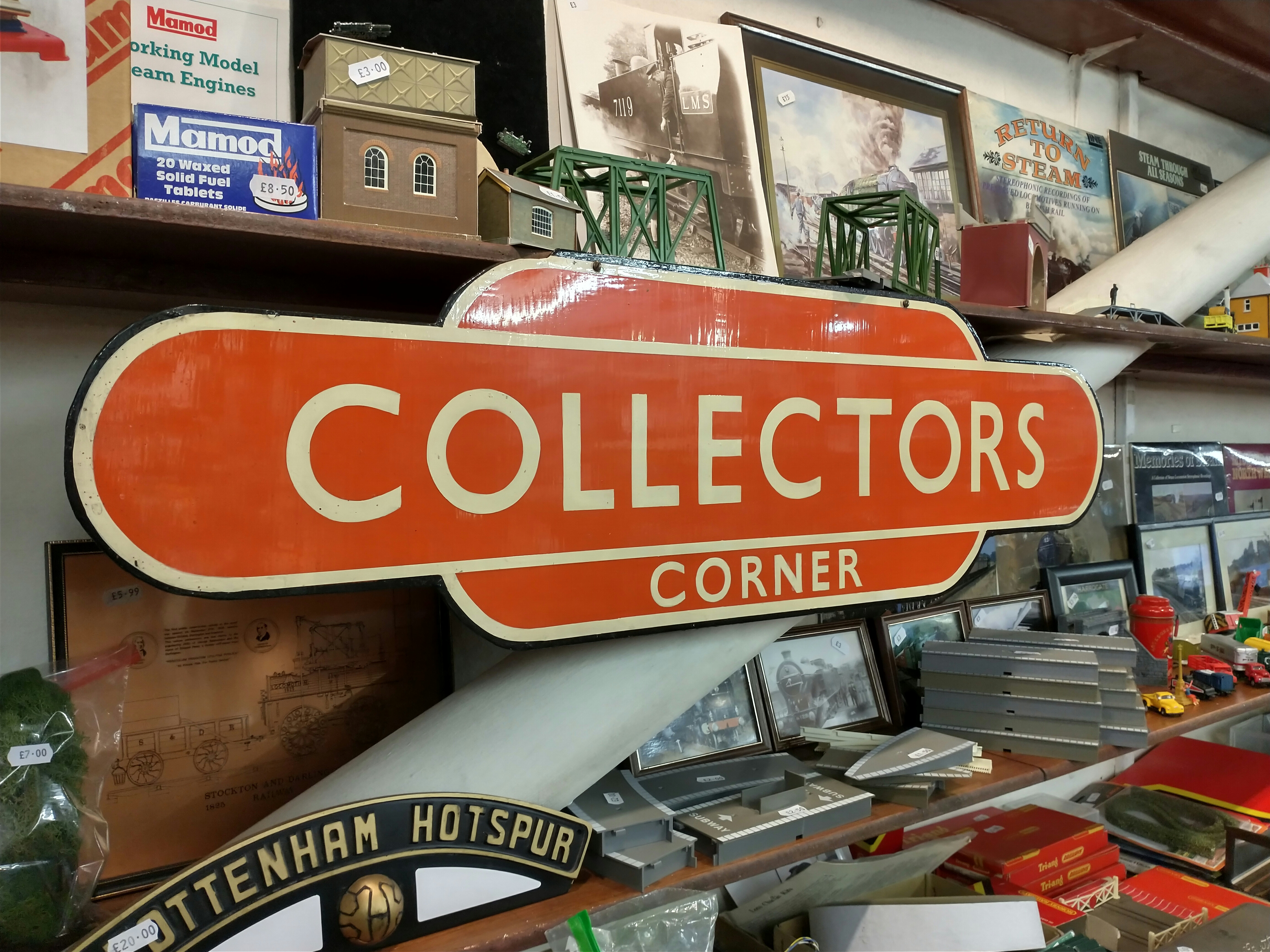 A orange and cream coloured period style sign with the words 'Collectors Corner' written on it.