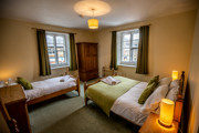 Grosmont Station House family bedroom with green furnishings and a white duvets.