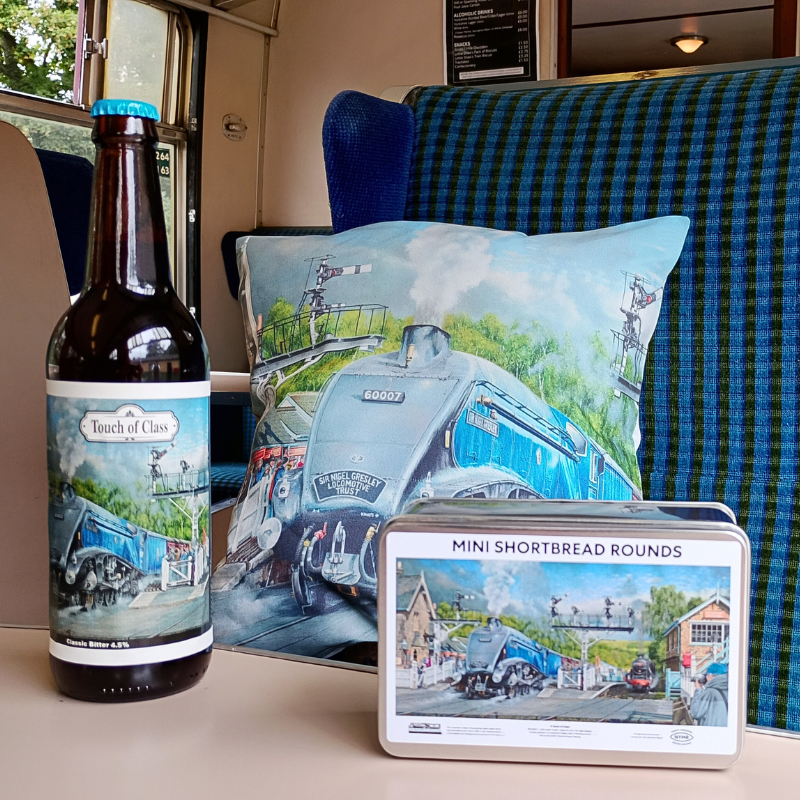 A selection of Sir Nigel Gresley merchandise including, beer, cushion and biscuit tin.