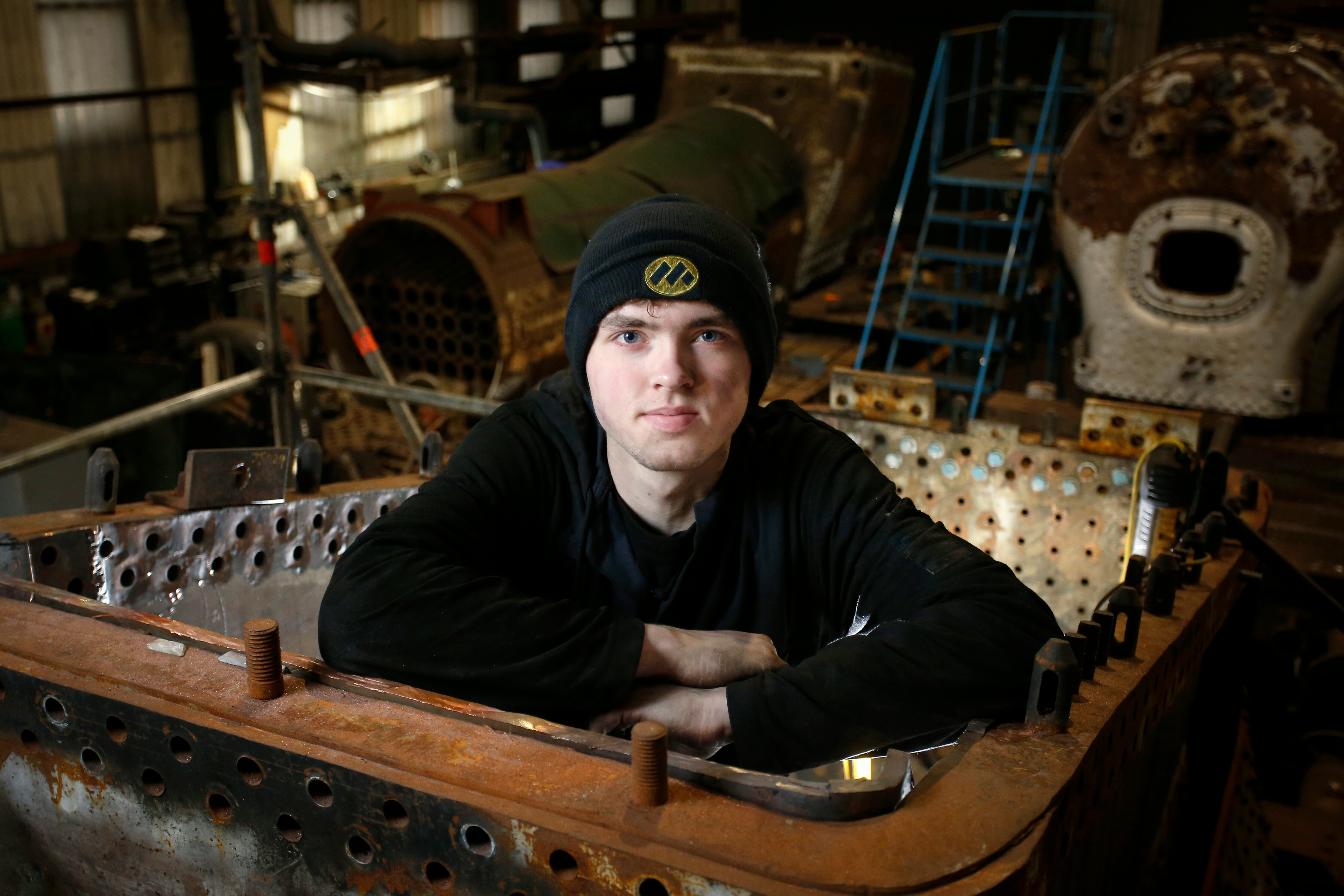 Apprentice Charlie Bauckham poses for a photograph in the firebox of a steam locomotive.