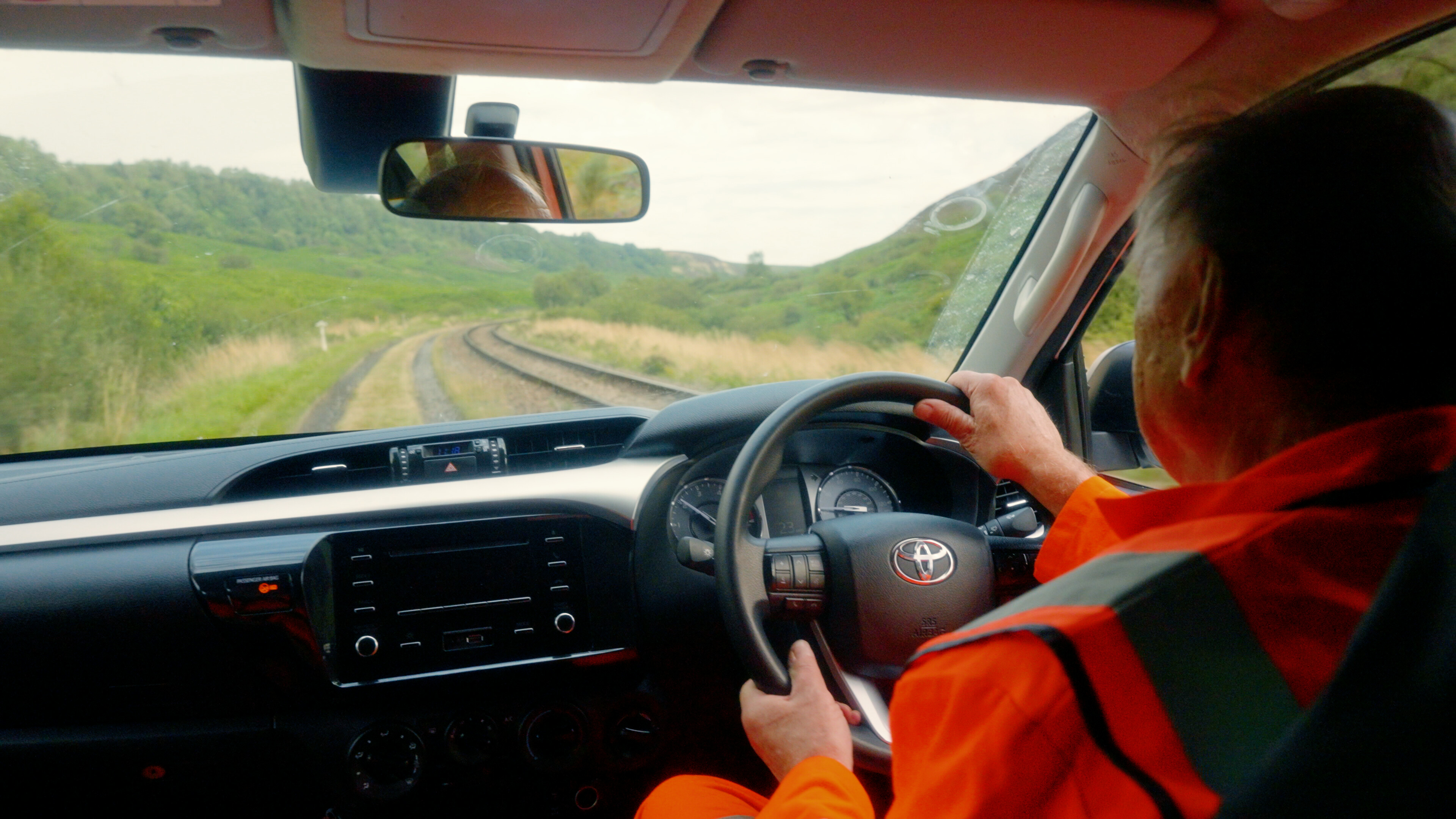 A volunteer drives along the lineside in the fire patrol vehicle.