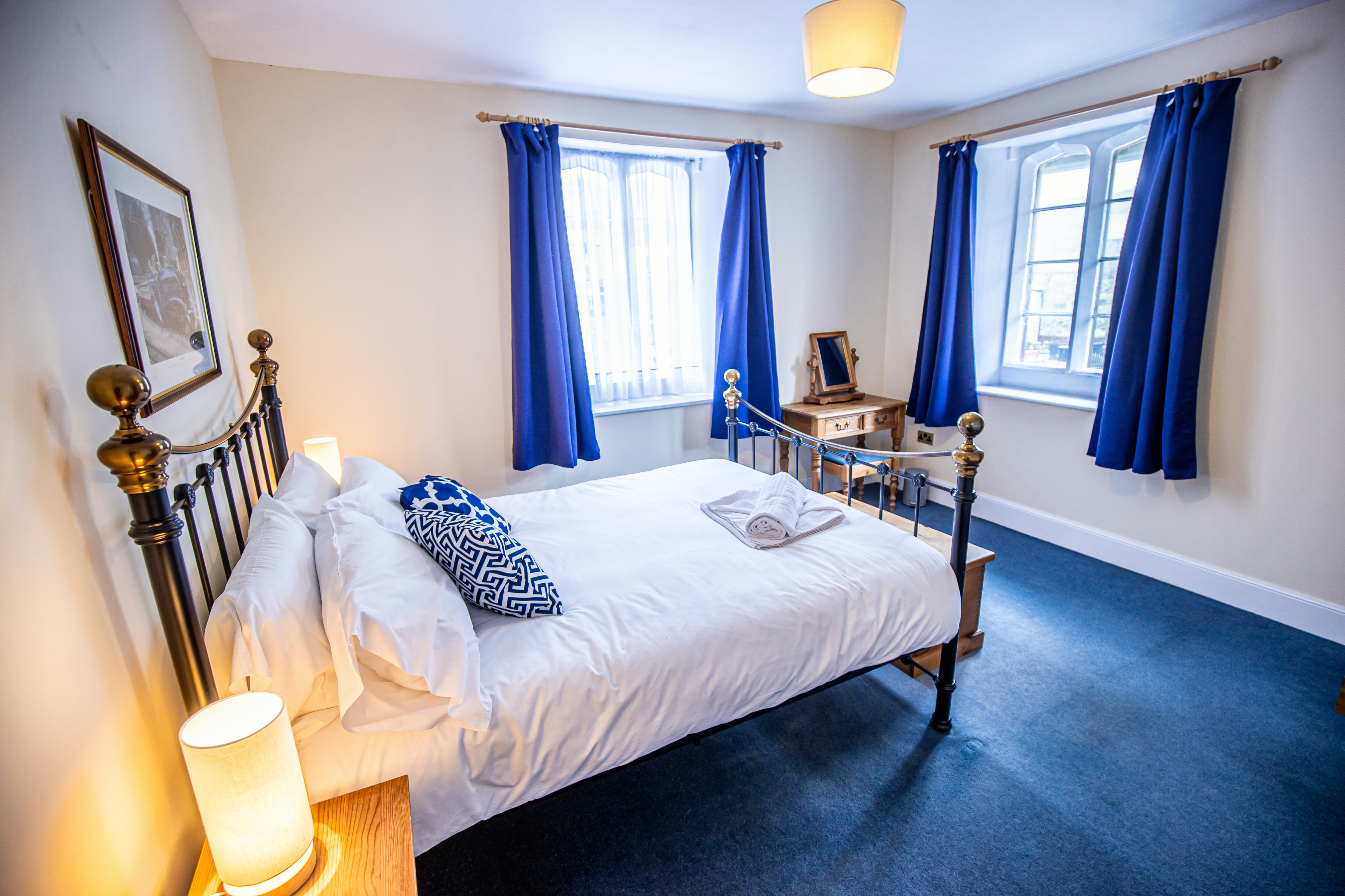 Grosmont Station House double bedroom with blue furnishings and a white duvet.