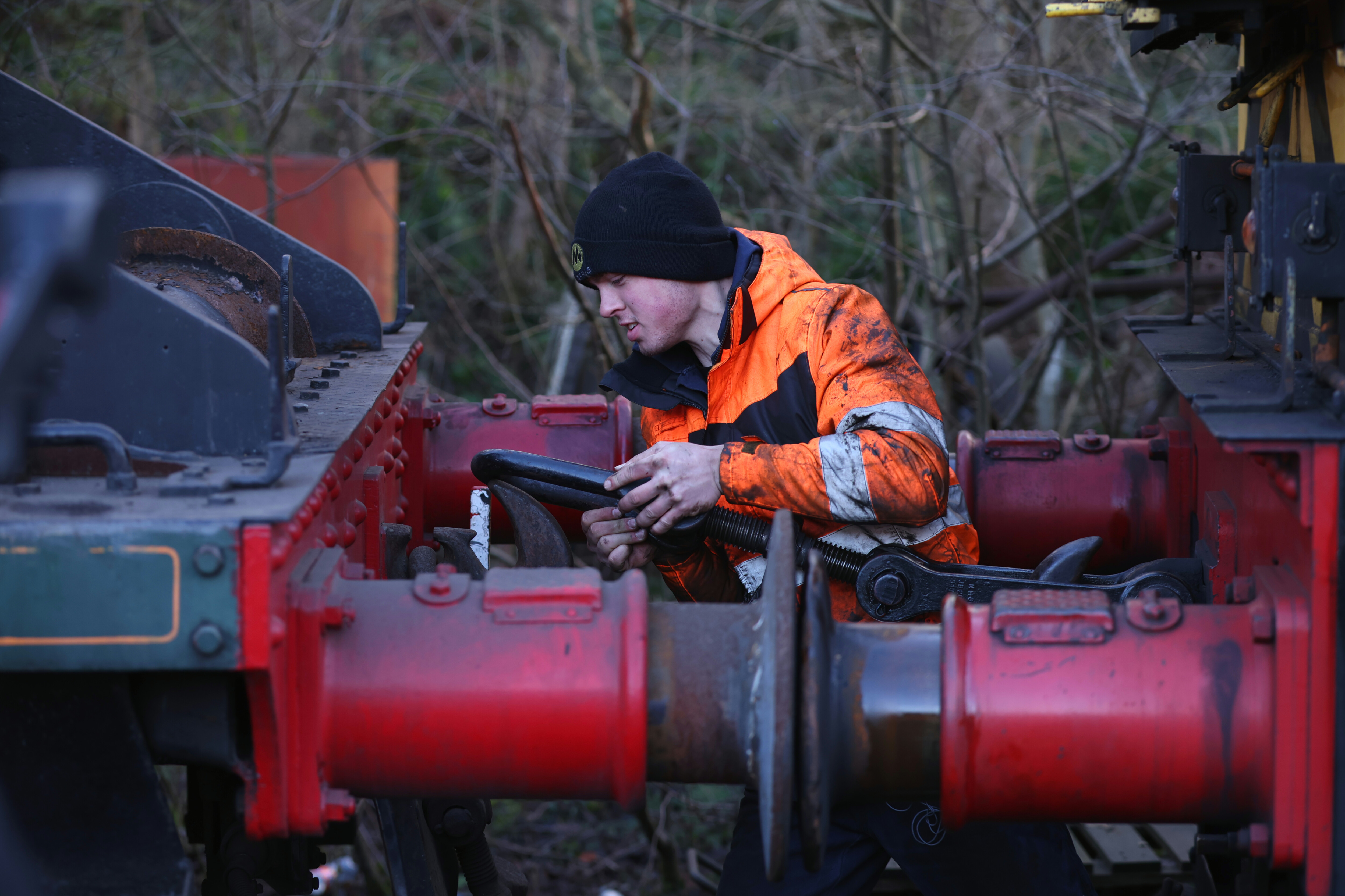 Apprentice Charlie Bauckham connects a buck-eye between to locomotives.
