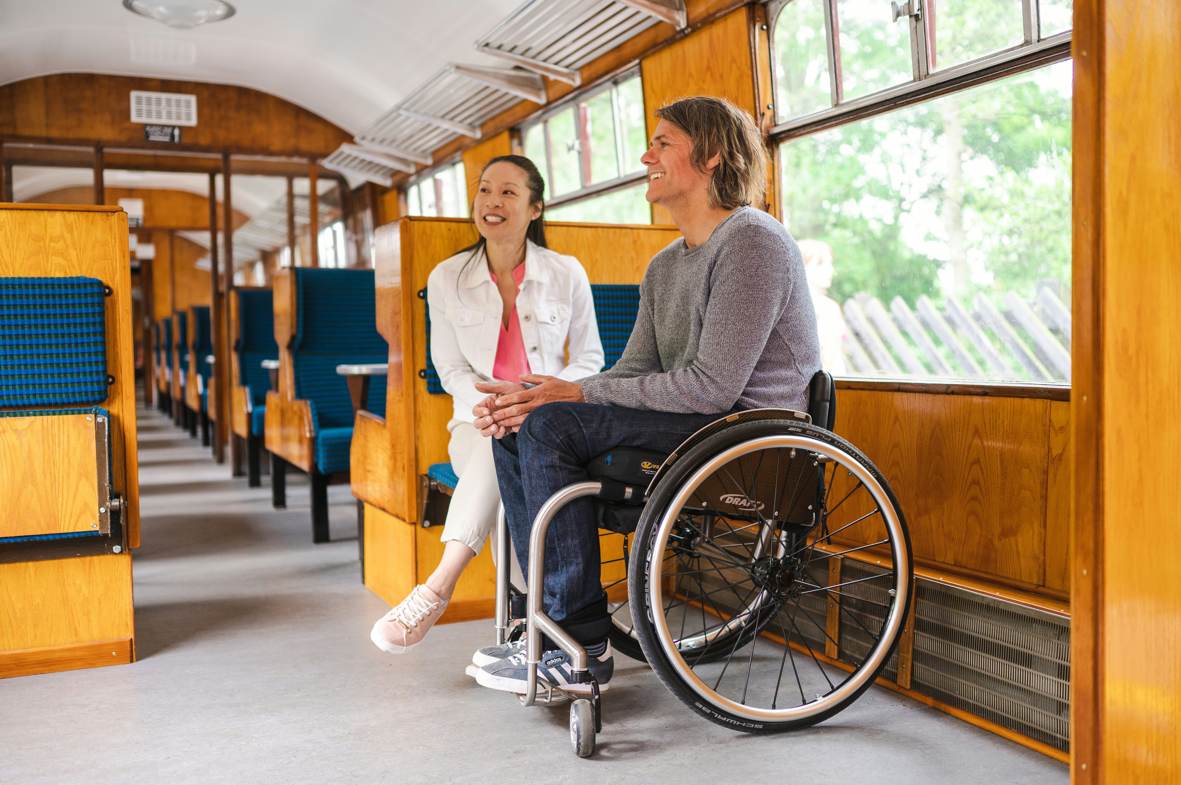 A couple, including a wheelchair user, enjoy the Fuss-Free carriage.
