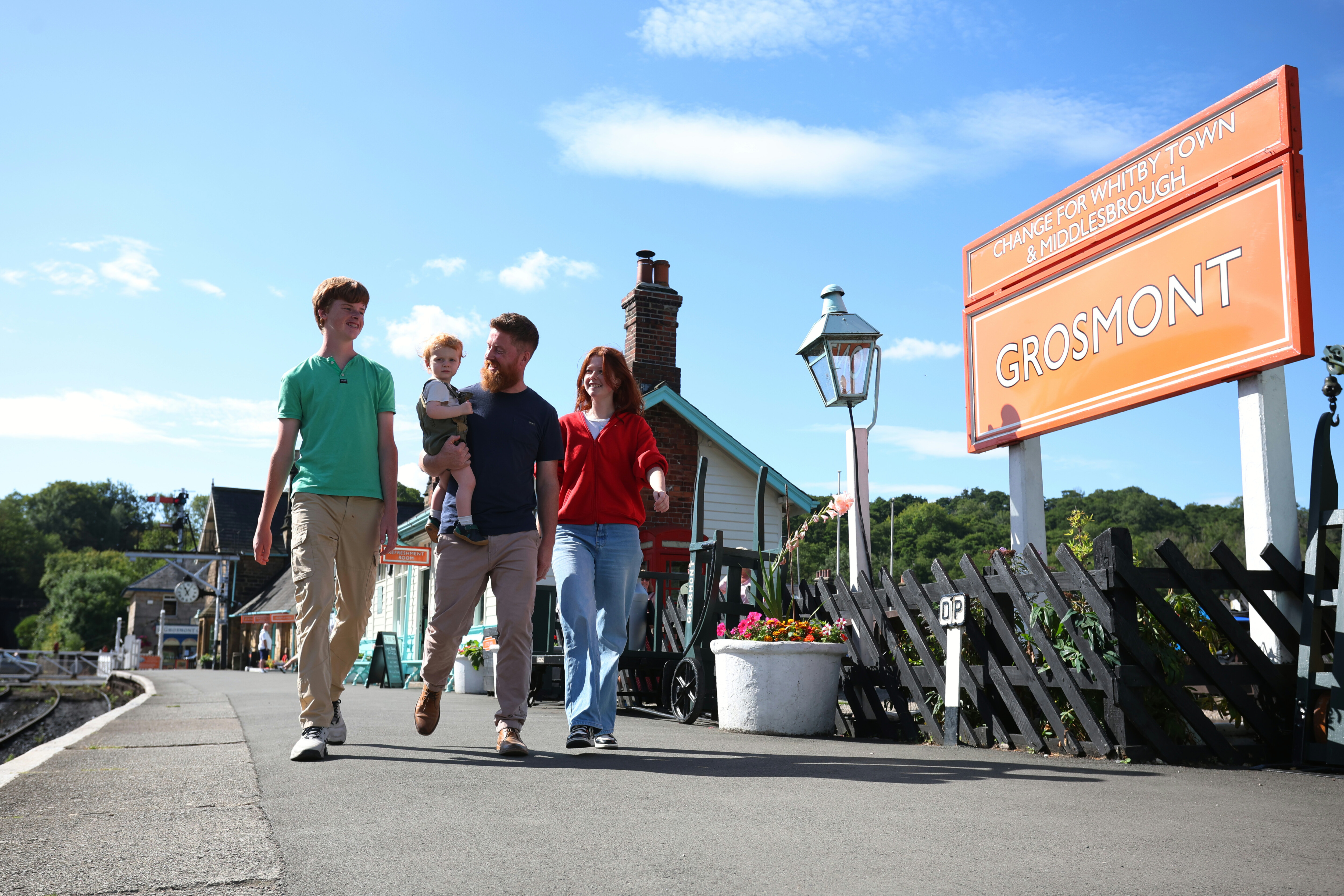 A family enjoy a walk along the platform at Grosmont Station.