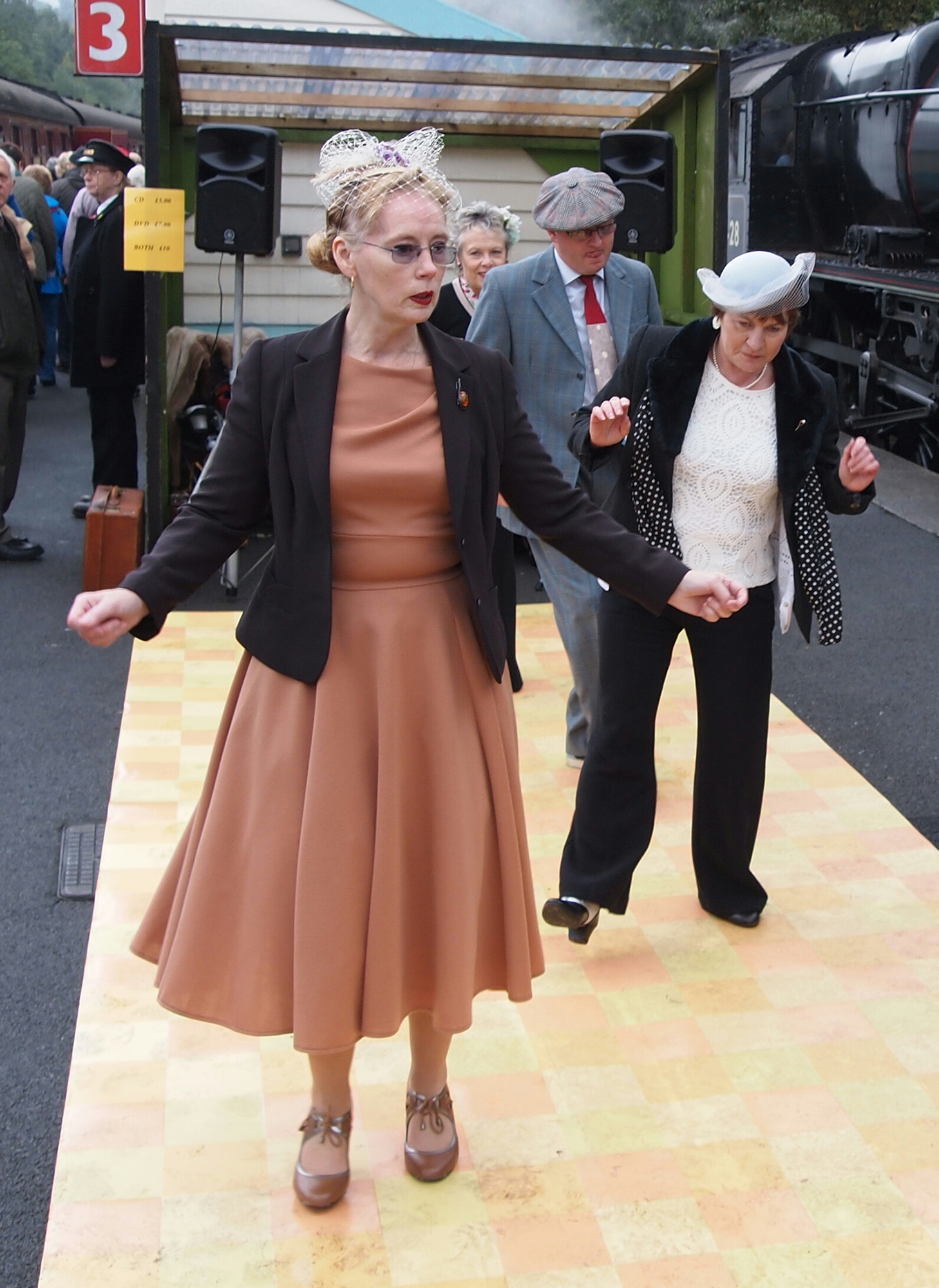 1940s dancers featuring a lady in a brown dress and brown shoes.