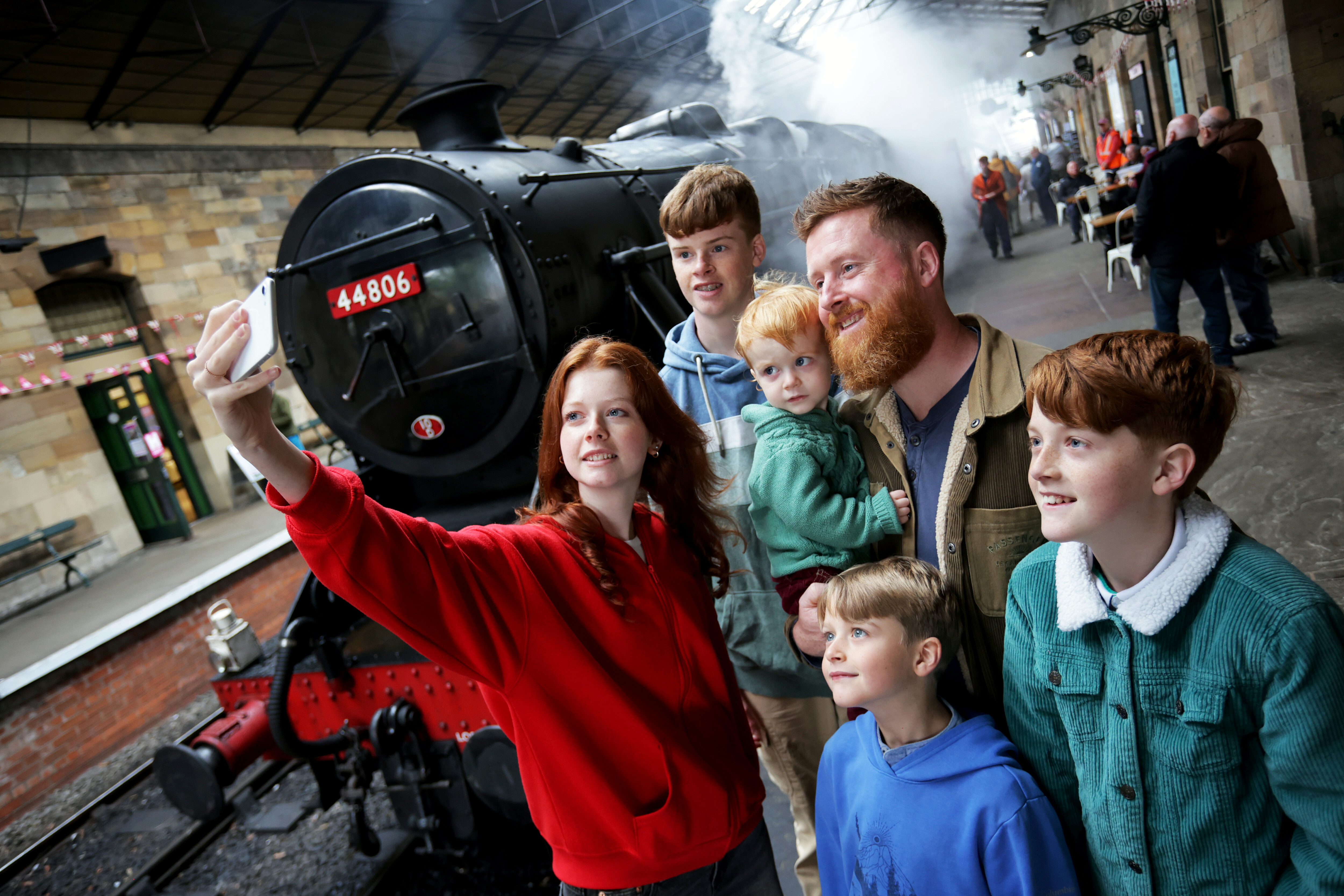 A family takes a selfie under the roof at Pickering Station.