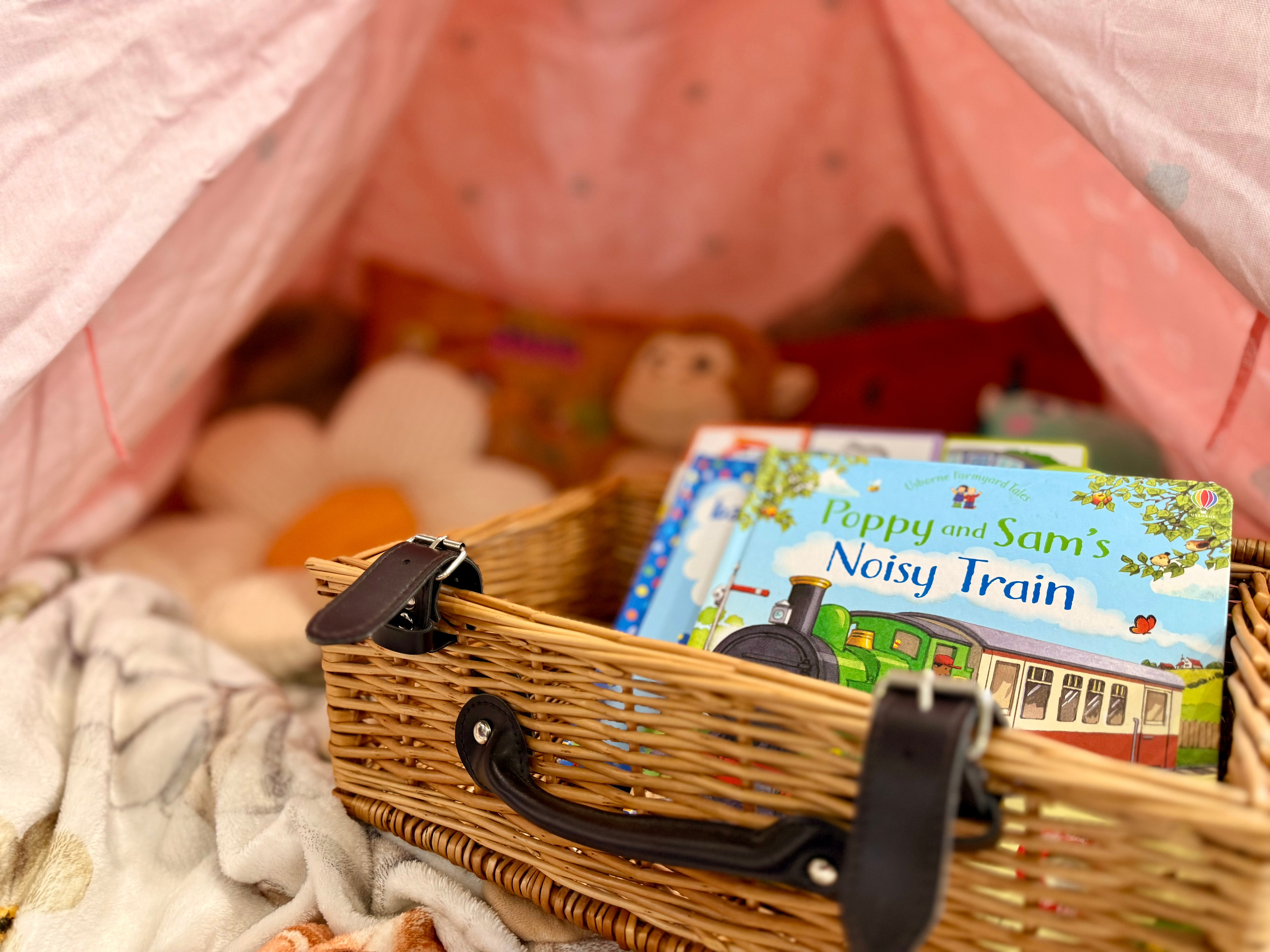 A basket with children's books inside it.