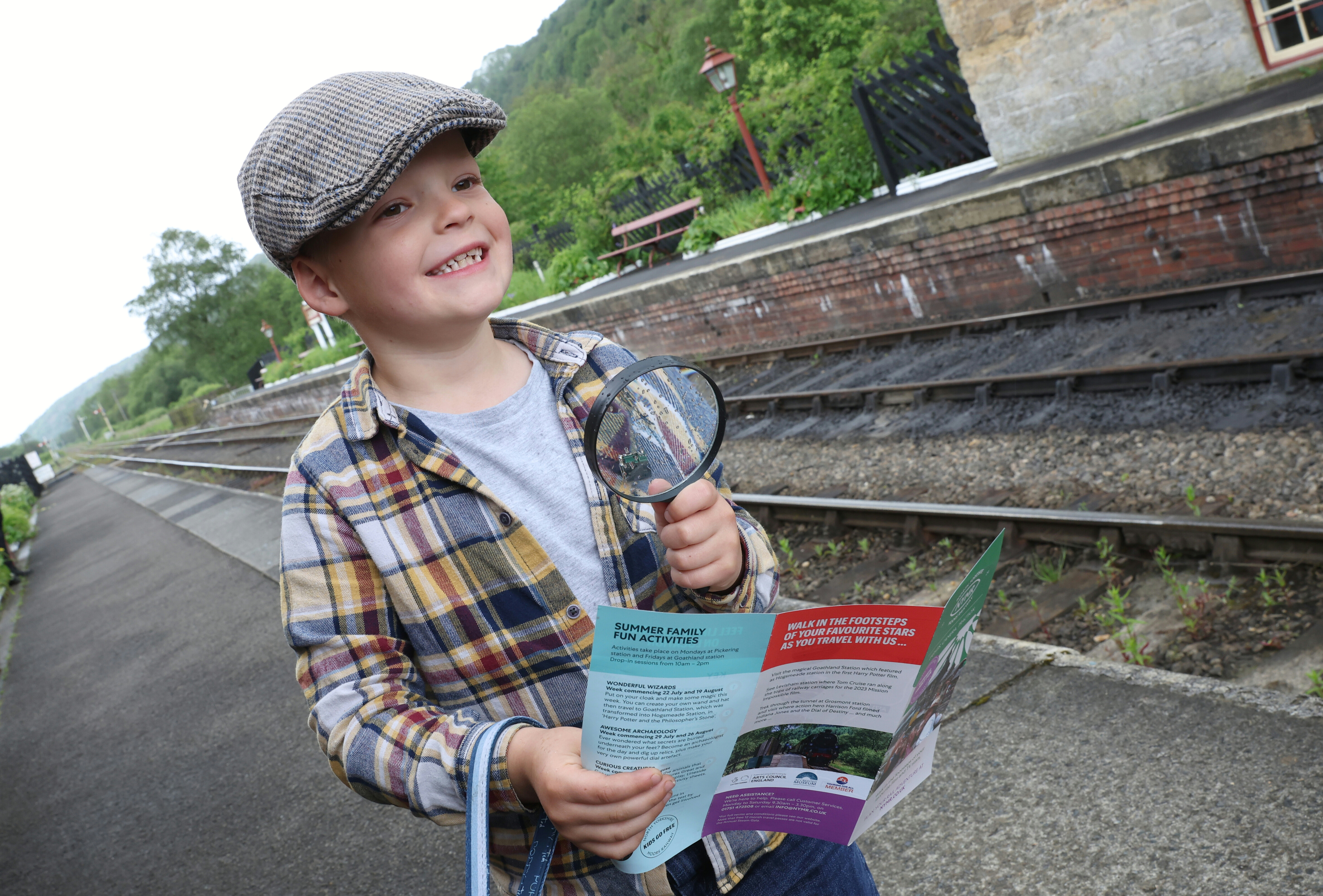 Boy with flat cap and magnifying glass