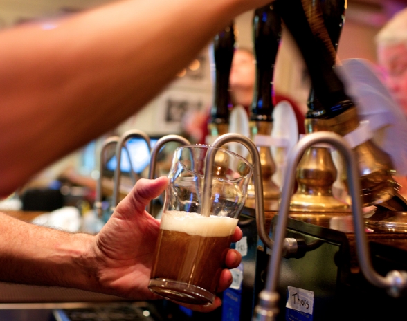 Someone pulling a pint of beer or ale.