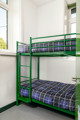 Green bunk beds at The Outstation with  purple tartan covers.