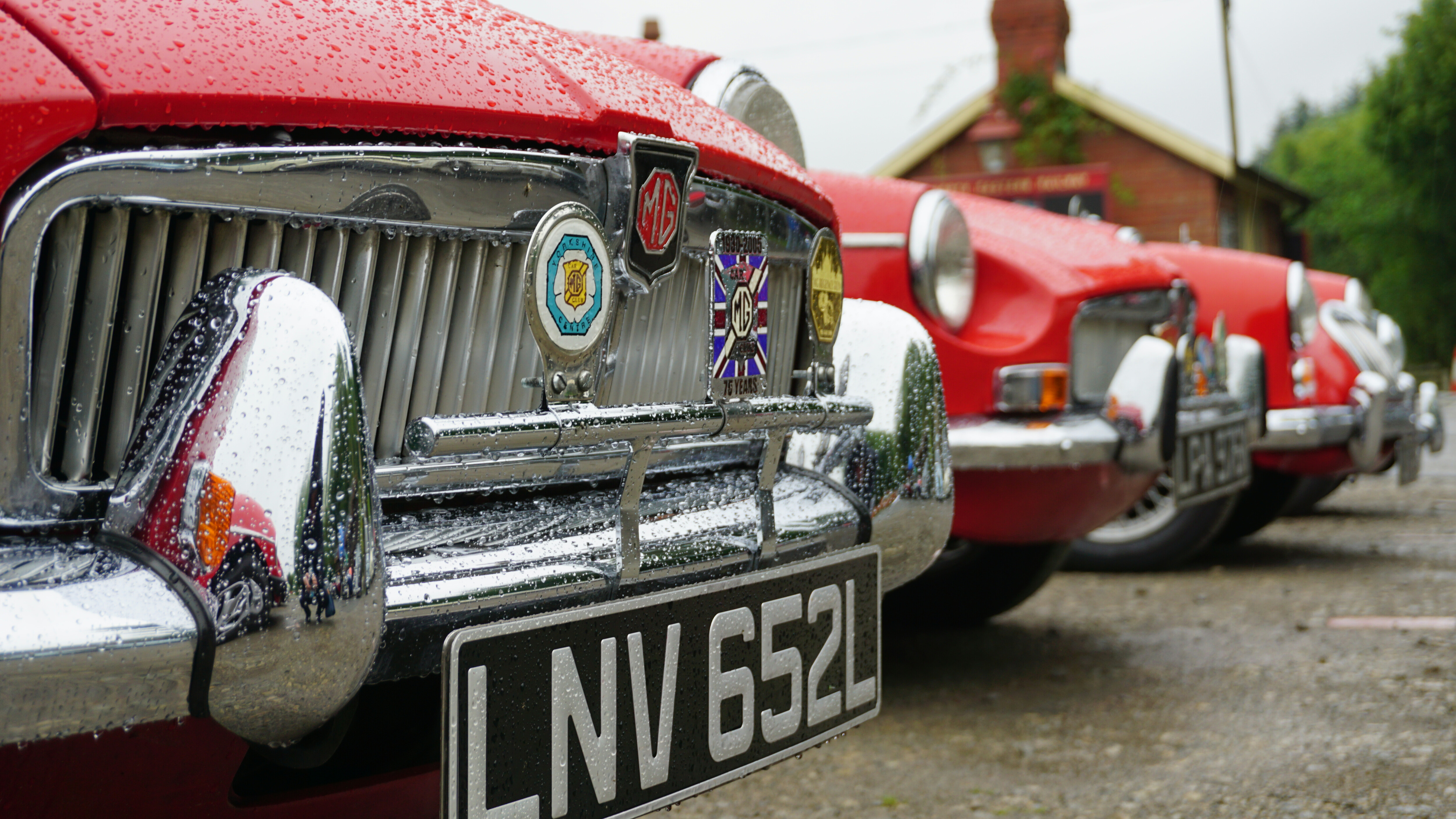 A selection of red cars, parked in a station car park.
