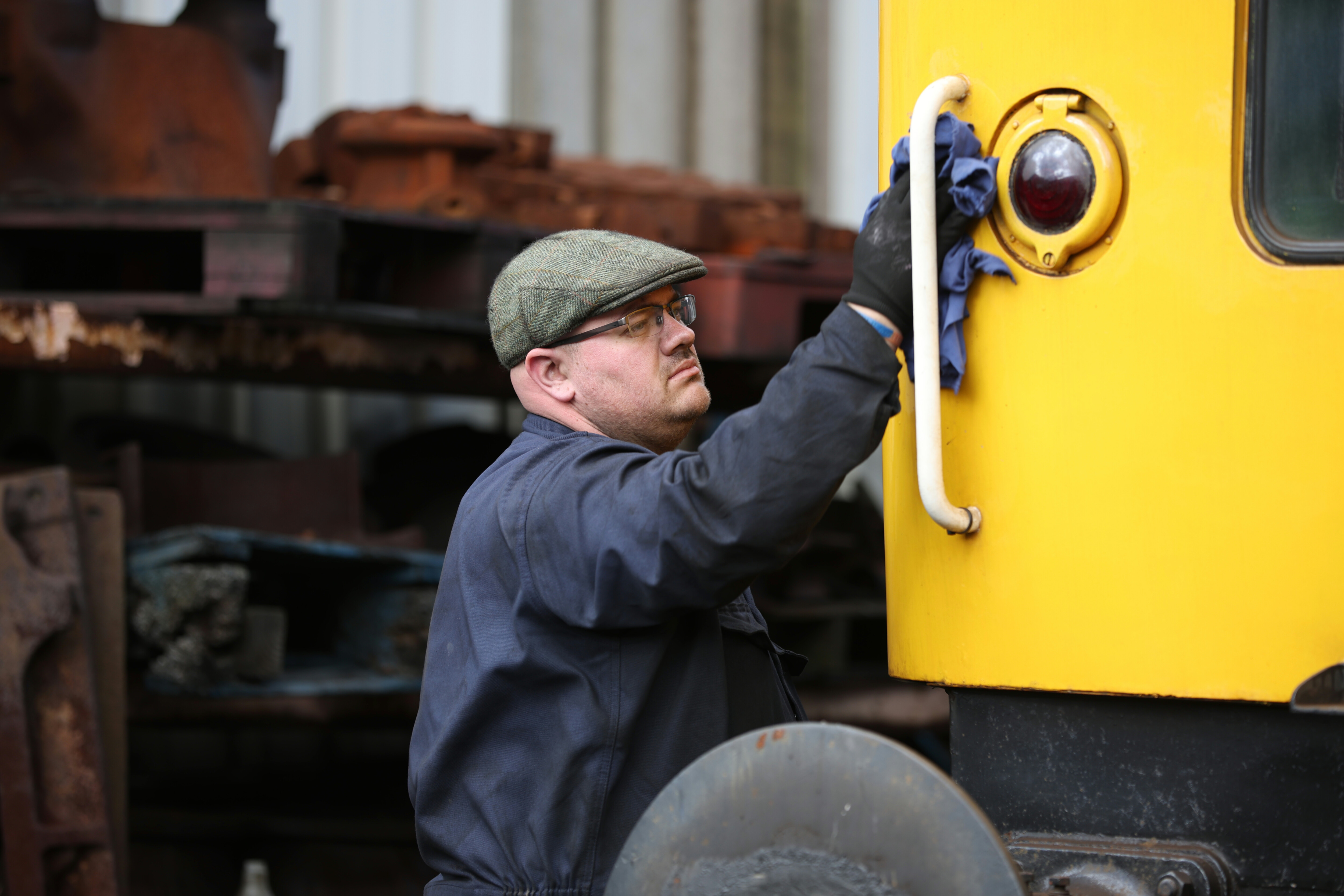 A member of the MPD team clean the paintwork of a diesel locomotive.