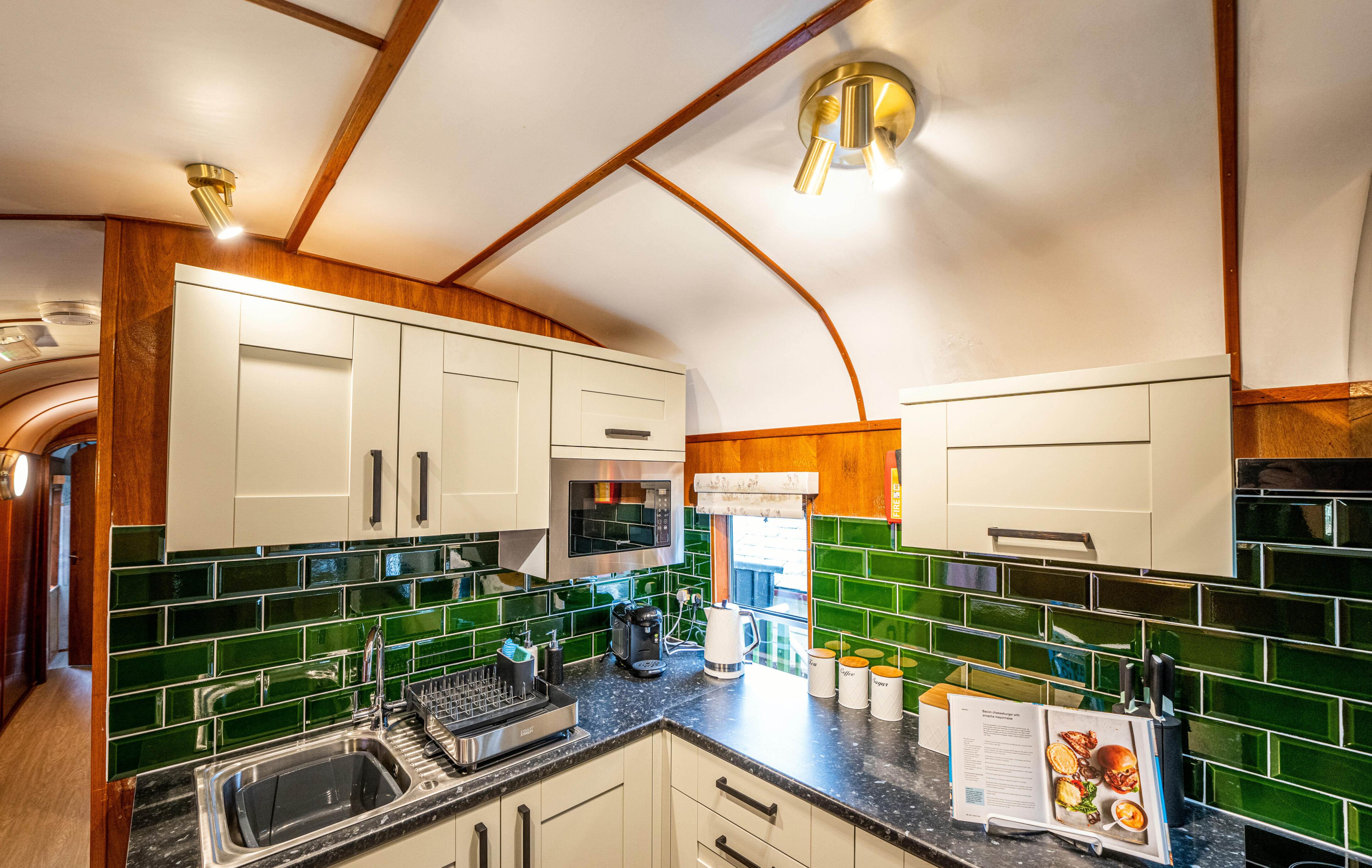 Goathland Camping Coach kitchen, with sink and a recipe book on display.