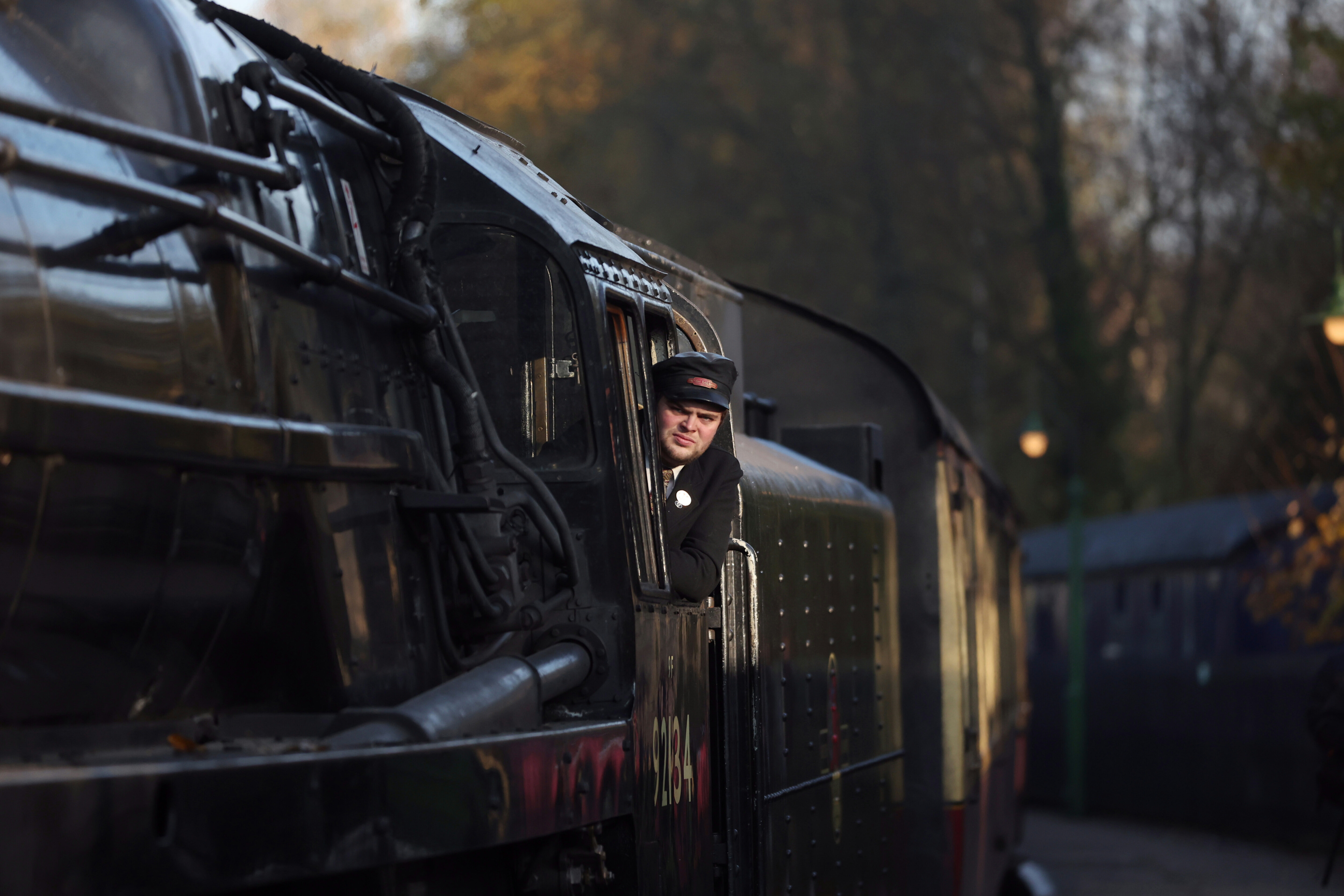 The driver of locomotive No. 92134 looks out the cab towards the camera.